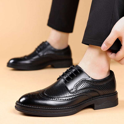 Black leather dress shoes being worn on a beige background