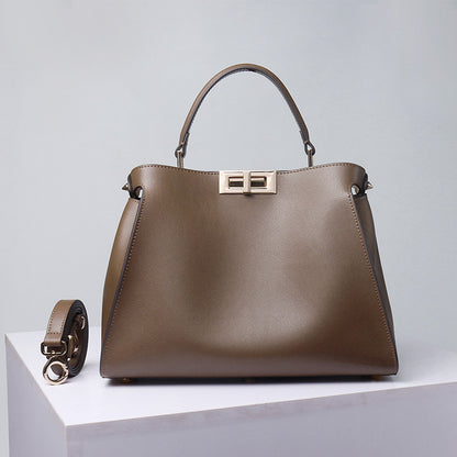Brown crossbody handbag with top handle, gold-tone lock clasp and side flap pockets