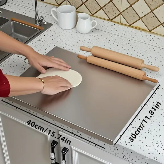 Large 304 stainless steel cutting board on a kitchen countertop featuring a non-slip pad and protective lid for food prep.