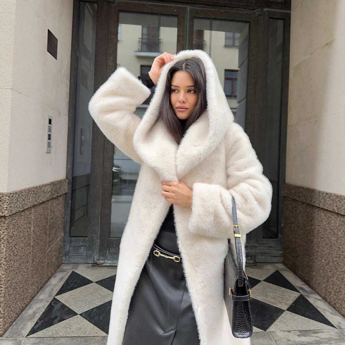 Woman wearing a white fur coat in an urban setting