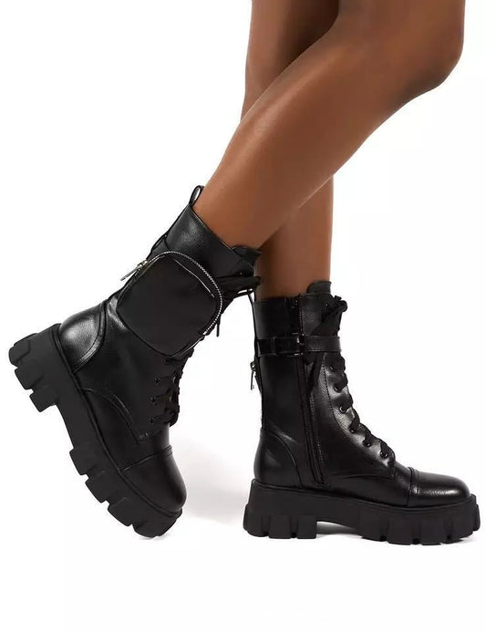 A pair of black high-top ankle boots with a chunky sole and lace-up closure, 