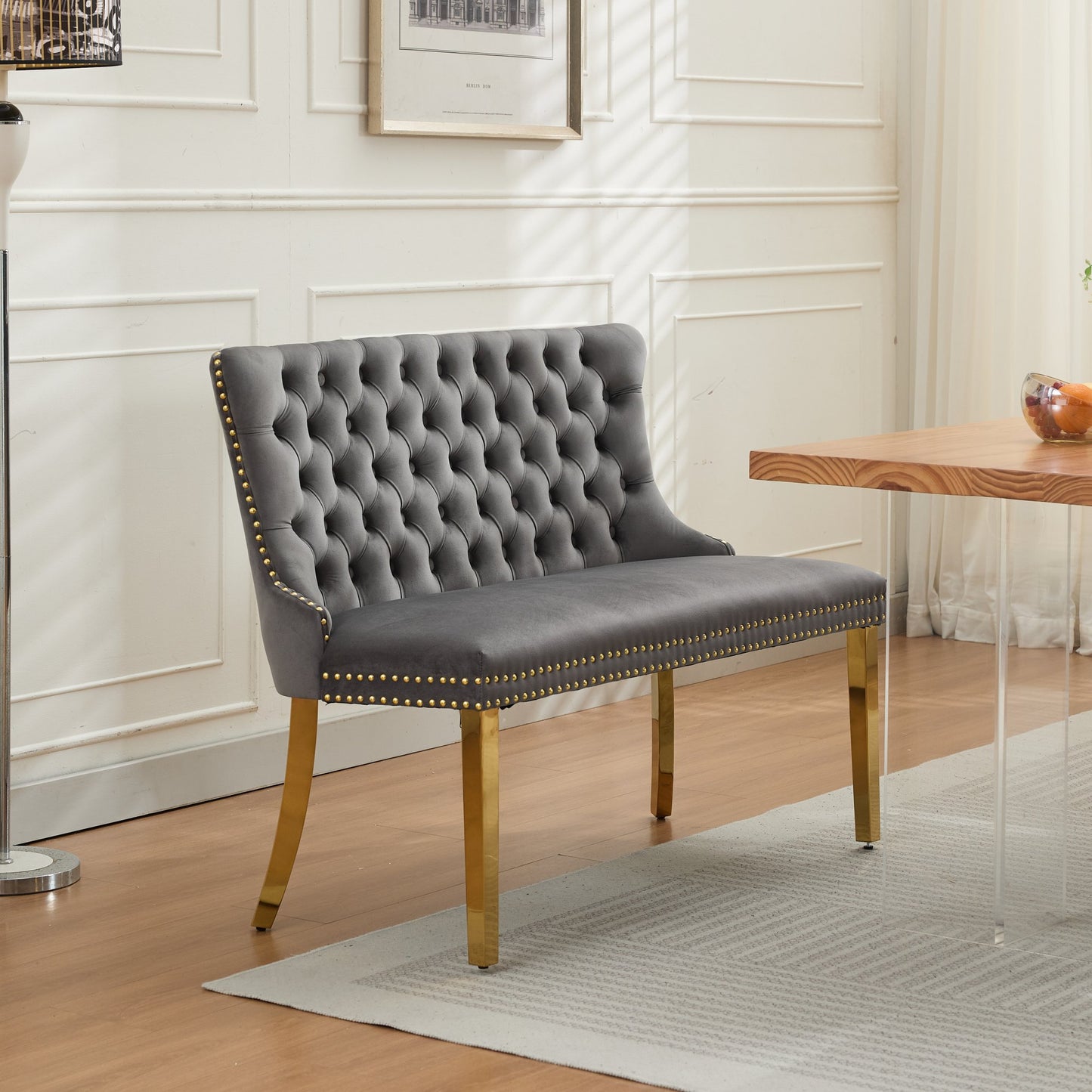 Mid-century modern gray velvet 2-seat dining bench featuring handmade button tufting, a high wingback, and polished gold-plated steel legs.