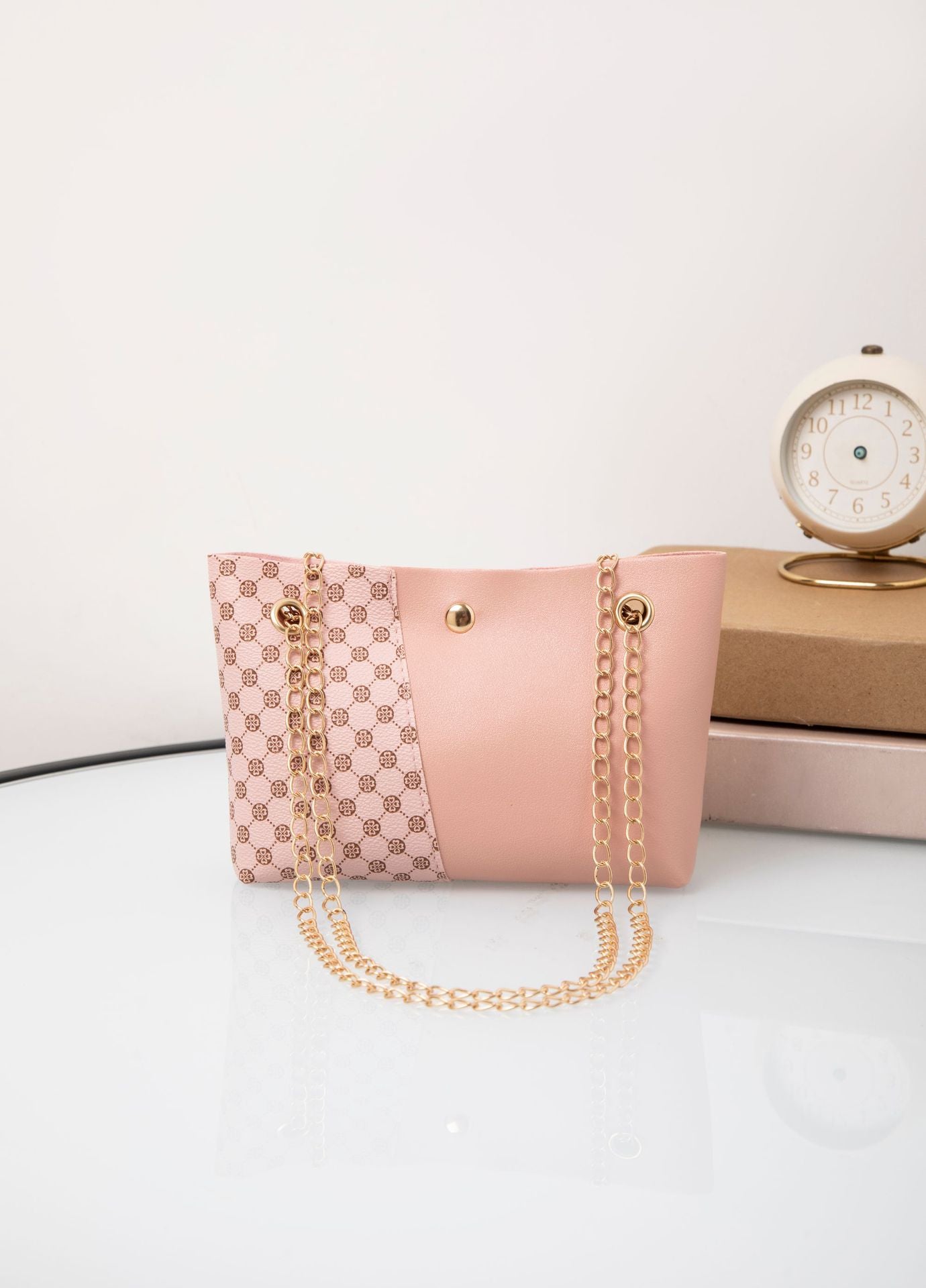 Light pink patterned shoulder bag with gold chain strap and round snap button