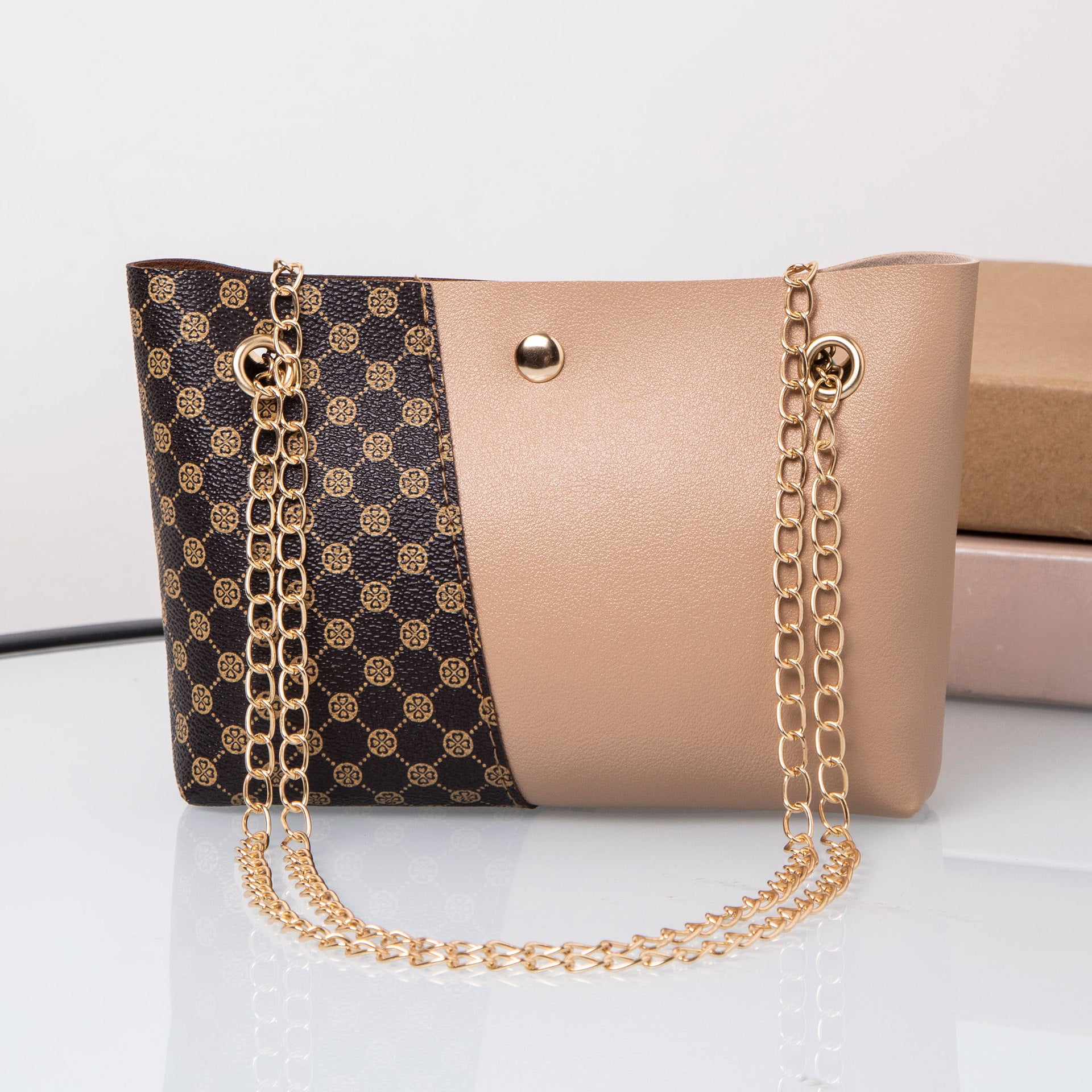 Beige and dark patterned shoulder bag with gold chain strap and round snap button