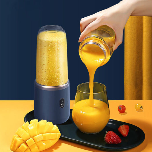 A portable rechargeable small household juice cup in operation, with citrus juice being poured into a glass on a table, alongside sliced citrus fruits.