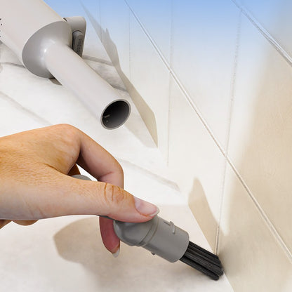 Person using a vacuum cleaner attachment to clean a corner.