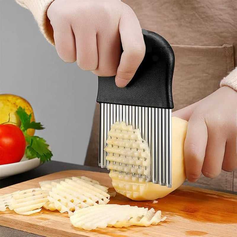 Black crinkle cutter slicer with wavy cutting blades, hand holding over potato