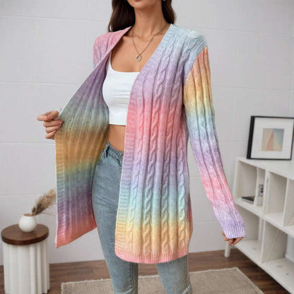 Woman wearing a colorful gradient cardigan in a room with a white wall and wooden floor.