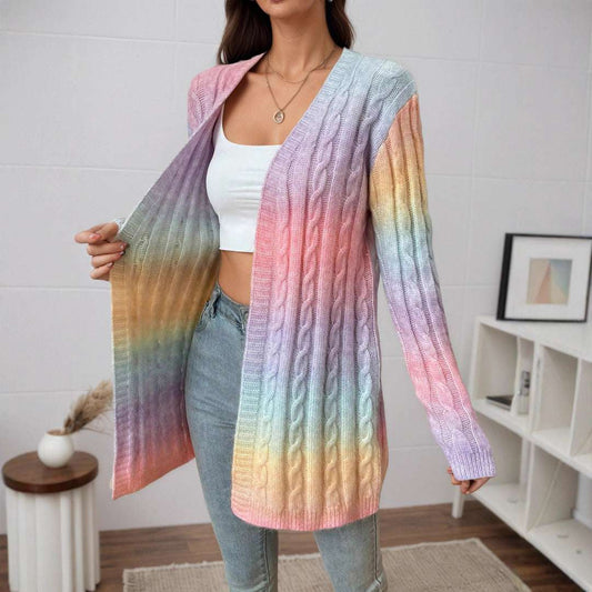 Woman wearing a colorful gradient cardigan in a room with a white wall and wooden floor.