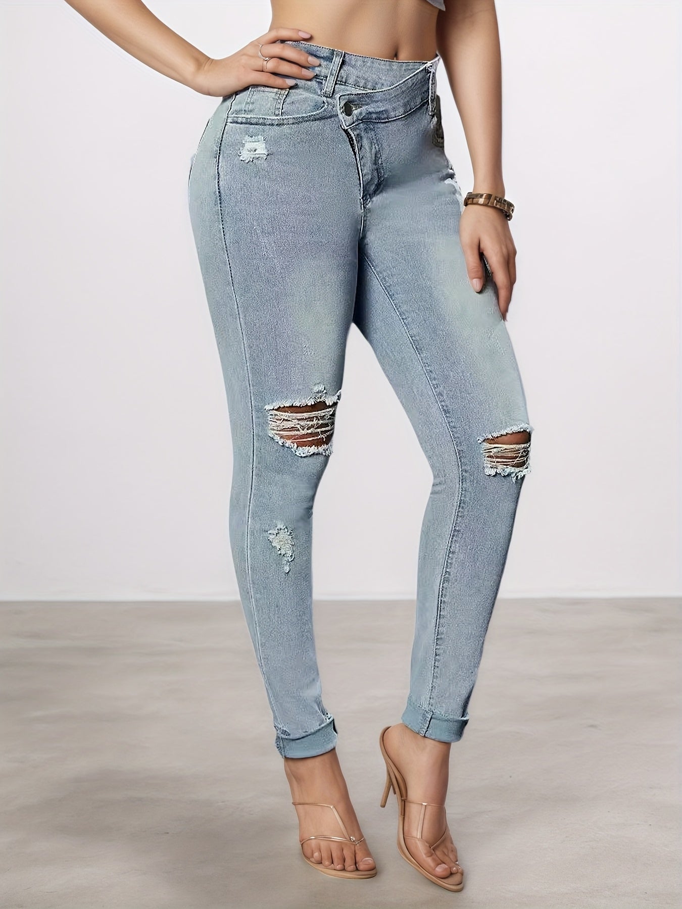Light blue slim-fit denim leggings with ripped knee tears and cuffed ankle hem