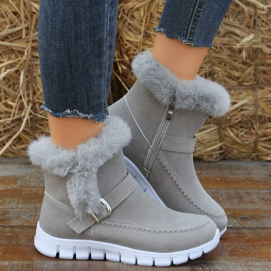 A pair of gray suede ankle boots with plush detailing and buckle design, featuring side zippers and white rubber soles.
