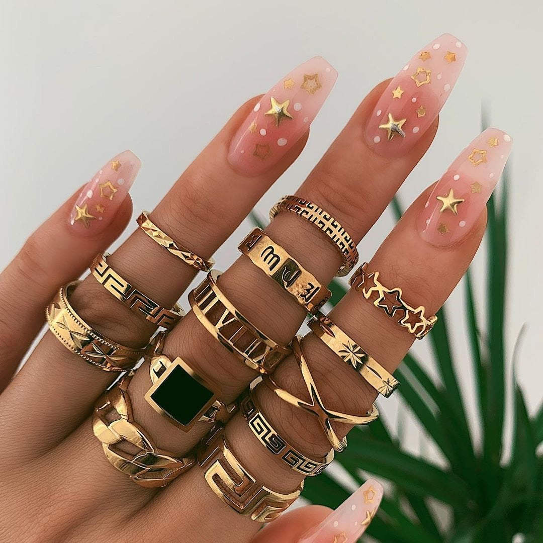 Gold-tone ring set with square green stone and star charm accents