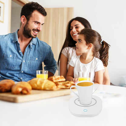 White mug warmer with two cups on the heating pad at a family breakfast table