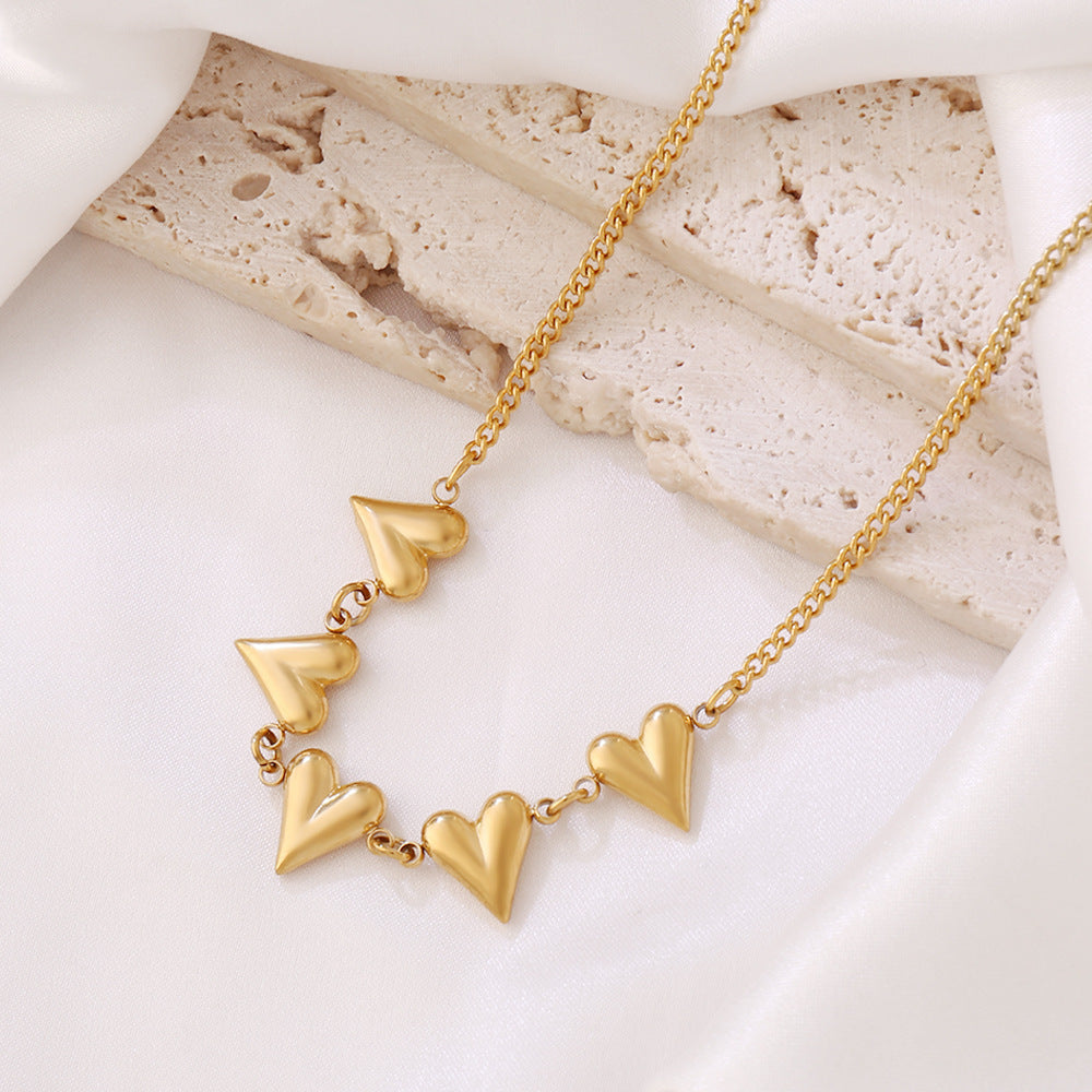 Gold heart pendant necklace with heart charm row on chain