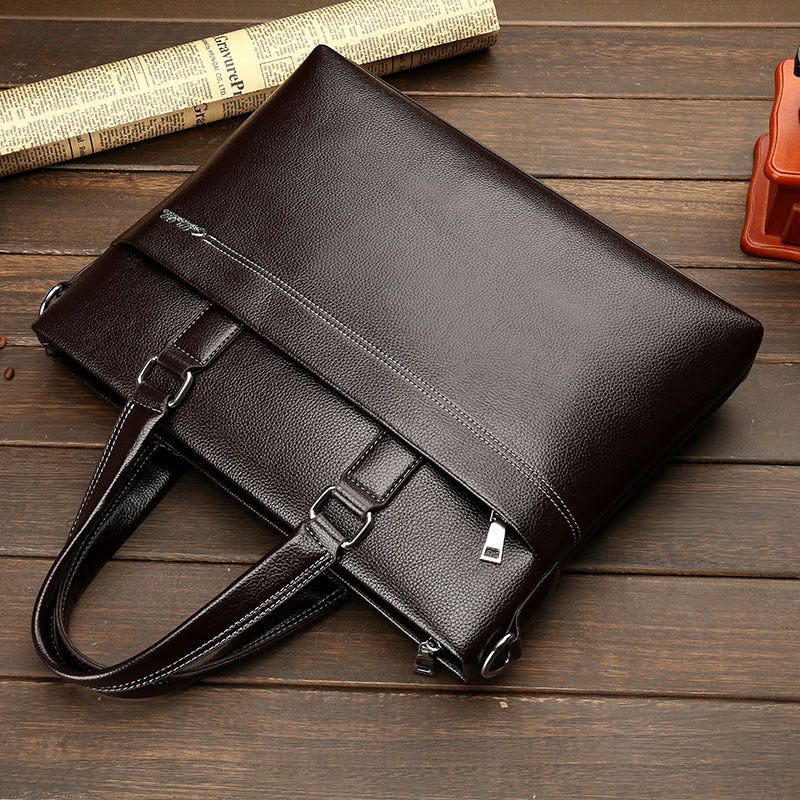 Men's leather one-shoulder computer bag with buckle strap and front zip pouch, dark brown.