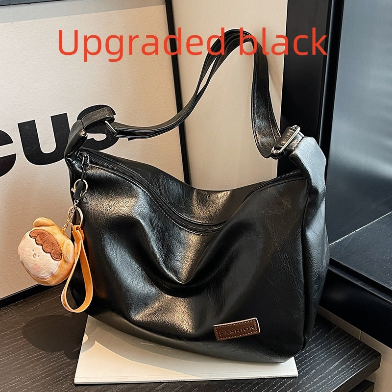Black hobo shoulder bag with pendant charm, slouch shape and magnetic top closure