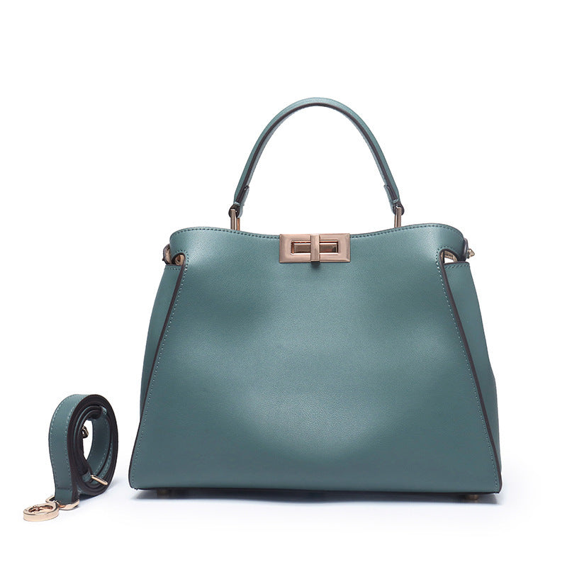 Blue-green crossbody handbag with centered metal clasp and top handles