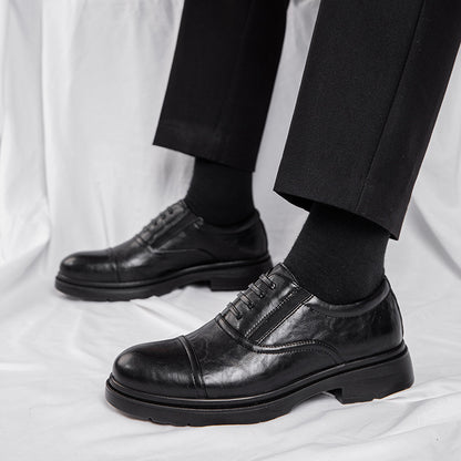Black leather dress shoes worn with black pants on a white background