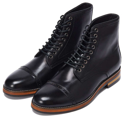 Pair of black leather boots with brown soles on a white background