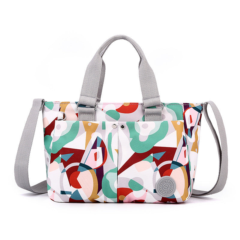 Waterproof shoulder bag, colorful geometric print with light gray straps and side pocket