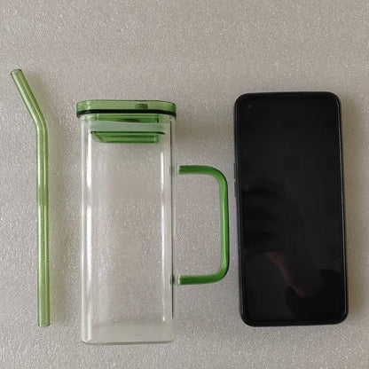 Clear square glass cup with green lid, green straw, and green side handle