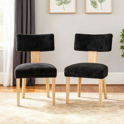 Pair of black upholstered dining chairs with light wood legs and padded backrests