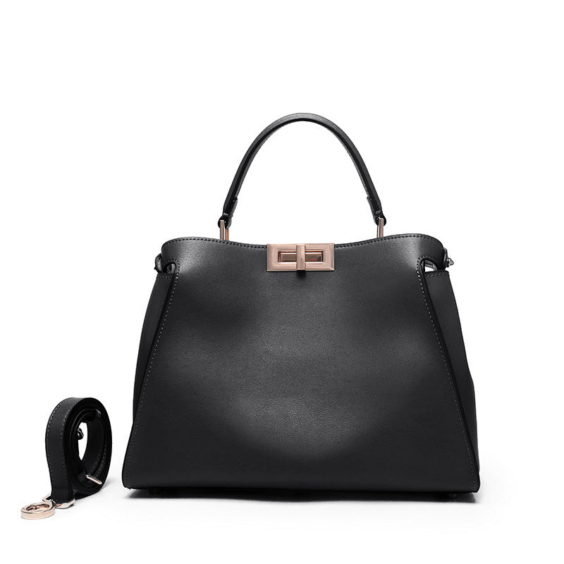 Black crossbody handbag with rose-gold lock clasp and short top handles