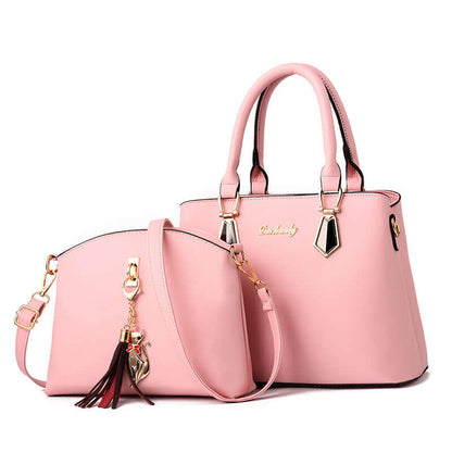 Pink faux-leather crossbody handbag with tassel charm, gold hardware, and shoulder strap