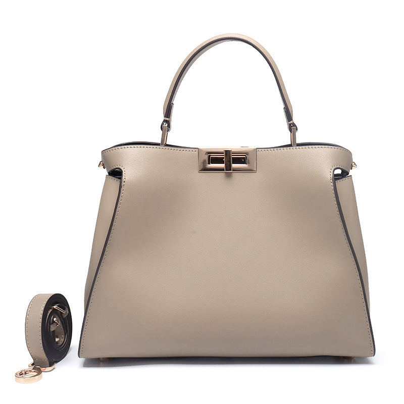 Beige structured crossbody handbag with top handles and gold-tone lock clasp