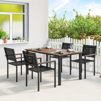 Outdoor dining set featuring acacia wood table and four dark mesh stackable chairs