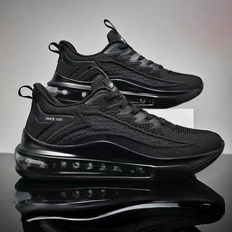 Black athletic shoes with a reflective surface on a gray background