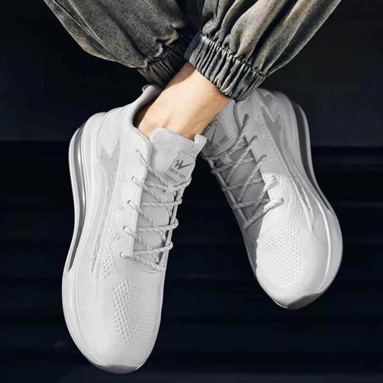 White sneakers worn with gray pants against a dark background