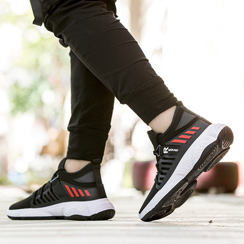 Black and red athletic shoes with white soles worn by a person on a blurred background