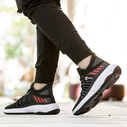 Black and red athletic shoes with white soles worn by a person on a blurred background