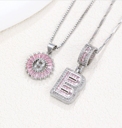 Silver-tone pendant necklace set showing pink crystal flower halo pendant and letter charm
