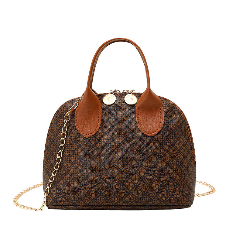 Brown patterned handbag with tan handles, chain strap, and round gold-tone clasps