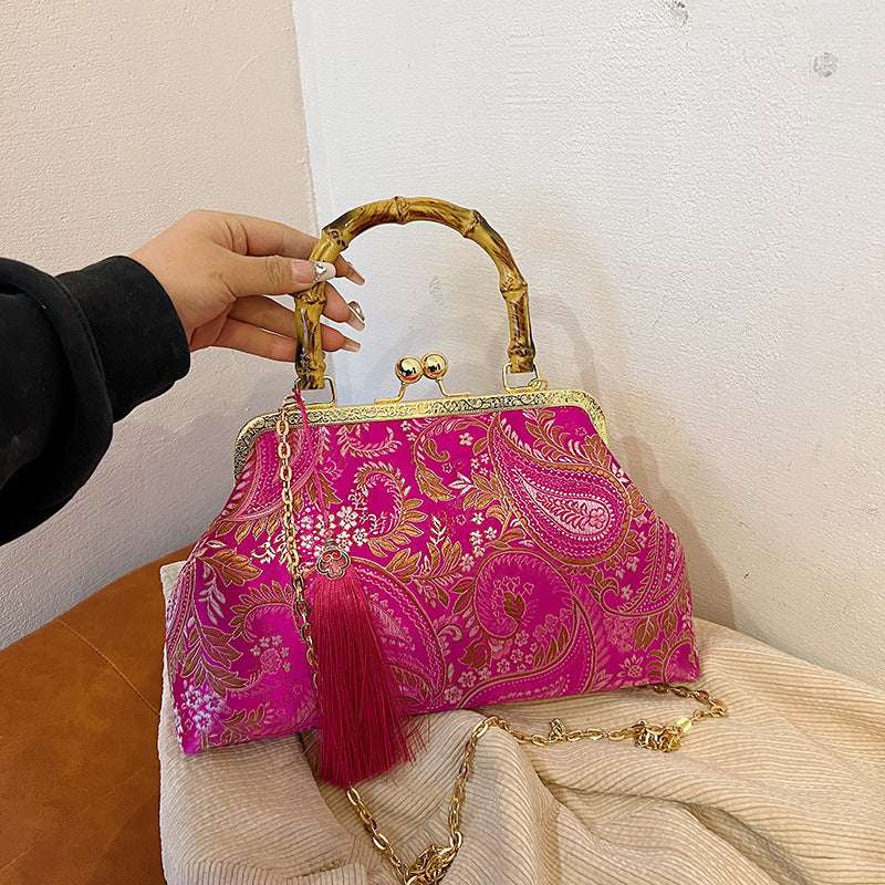 Magenta paisley satin clutch with bamboo handle, frame clasp, tassel and gold chain