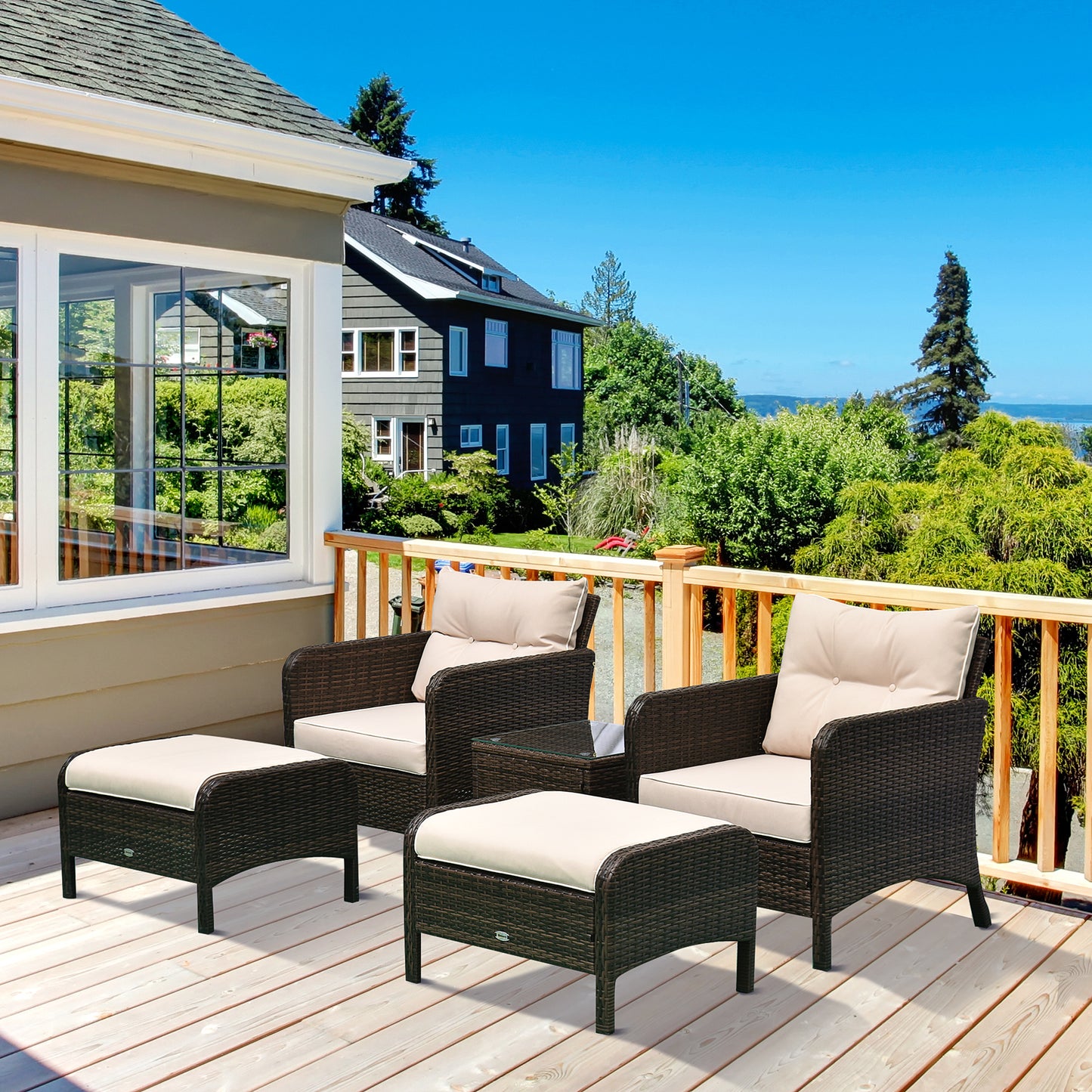 Two wicker lounge chairs with beige cushions and dark frames on outdoor deck