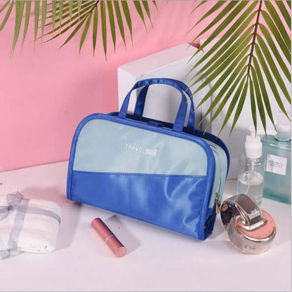 Cosmetic storage bag with blue front panel, clear window, and blue top handle.