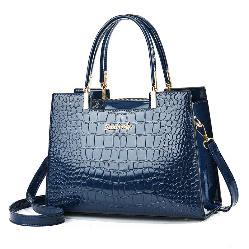 Blue croc-texture handbag with top handles, gold hardware, and crossbody strap