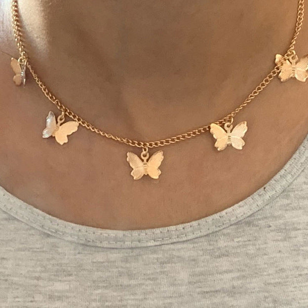 Gold butterfly pendant necklace with five butterfly charms and a central butterfly pendant