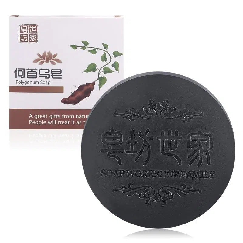 Black soap bar with branding and packaging on a white background