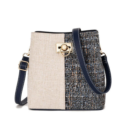 Two-tone textured bucket bag with cream panel, dark speckled side, gold clasp, crossbody strap