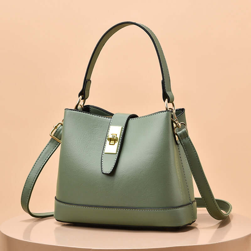 Light green tote handbag with gold clasp and shoulder strap