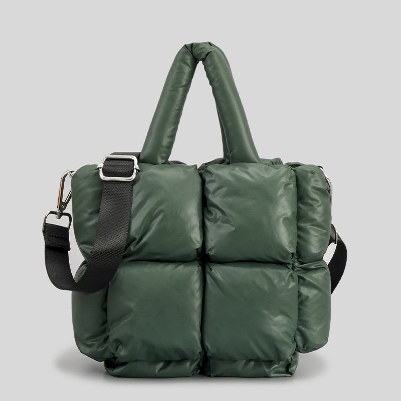 Dark green puffer handbag with top handles, black shoulder strap, and metal buckle