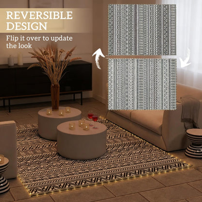 Reversible outdoor rug with dark geometric pattern and gold-edged border on tile floor