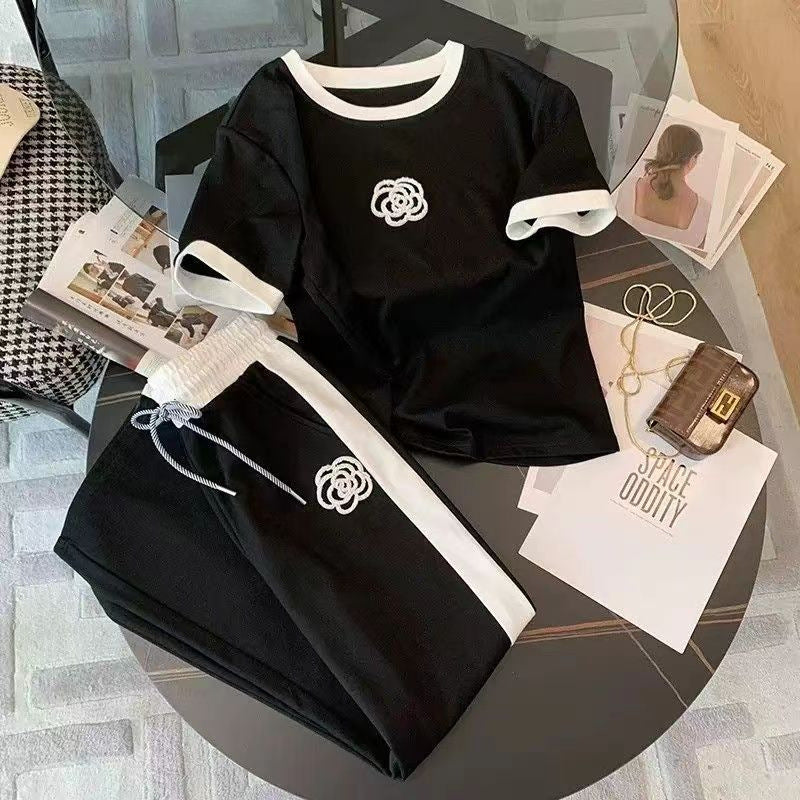 Women's two-piece set in black: short-sleeve tee with white trim logo and wide-leg pants