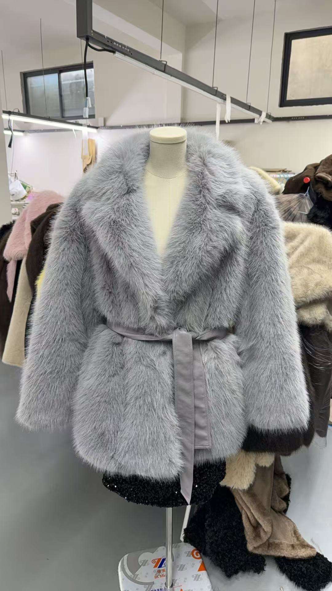Mid-length faux wool coat in light gray on mannequin with plush collar and waist tie