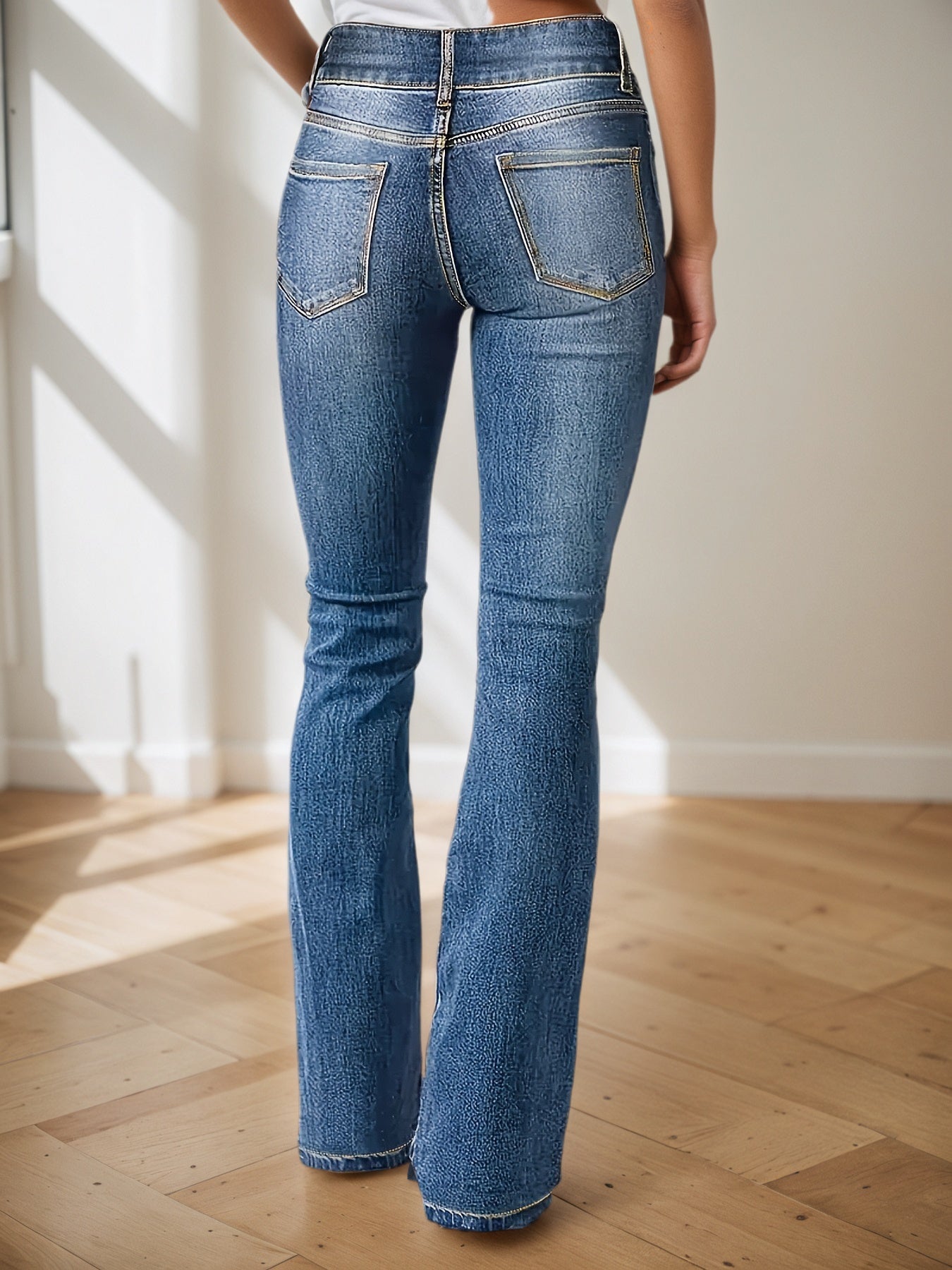 Blue high-waisted jeans with slight flare, back pockets, belt loops, and button closure
