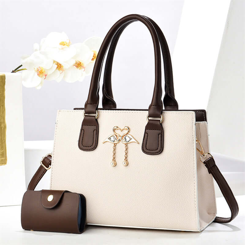 White large crossbody tote bag with brown handles, front heart charm, and side pouch